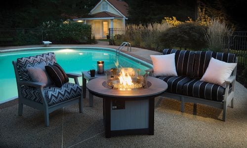 Outdoor furniture around fireplace at night