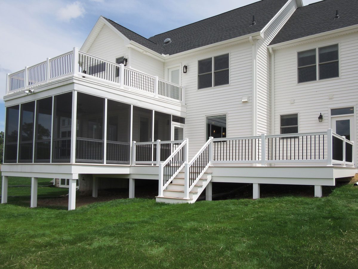 A home with white siding and a screened-in porch.