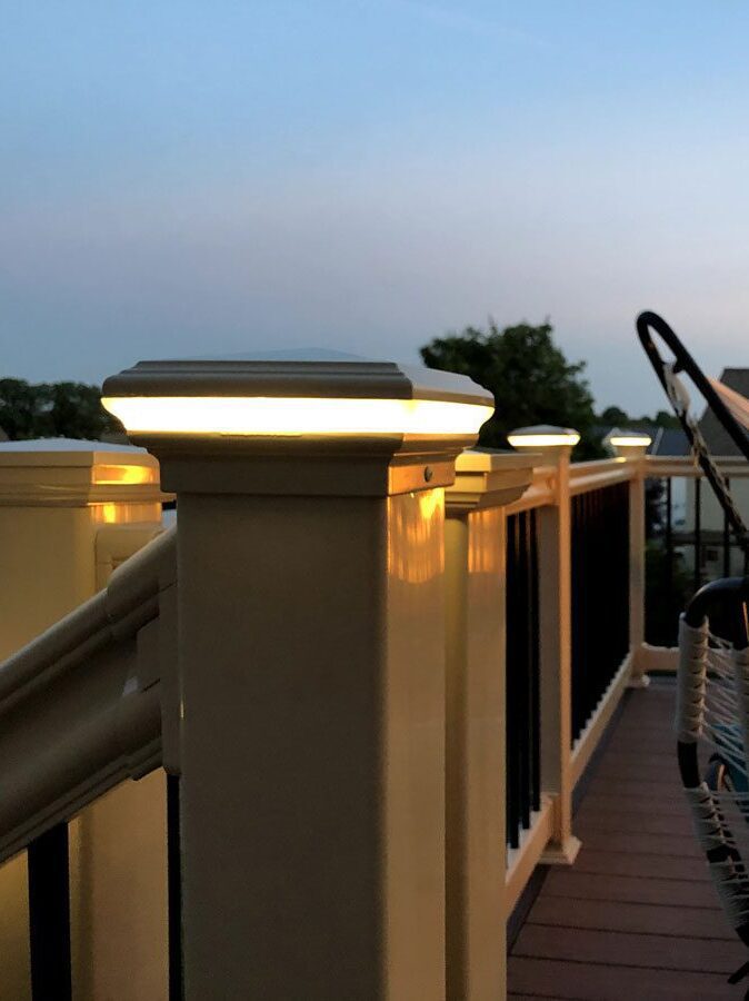 A view of white deck railing with matching post cap lights