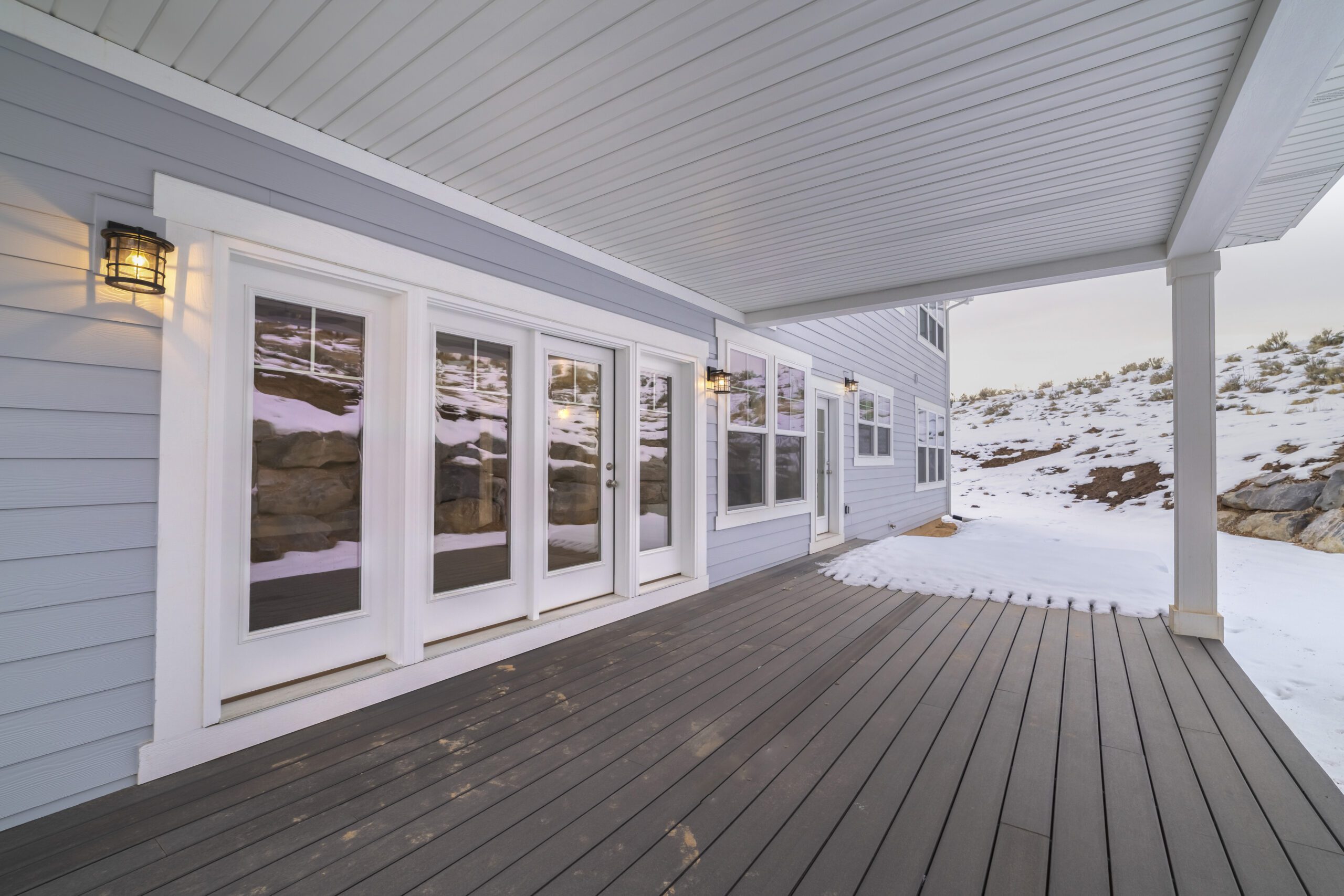 A vinyl deck is shown with one part of it covered in snow.