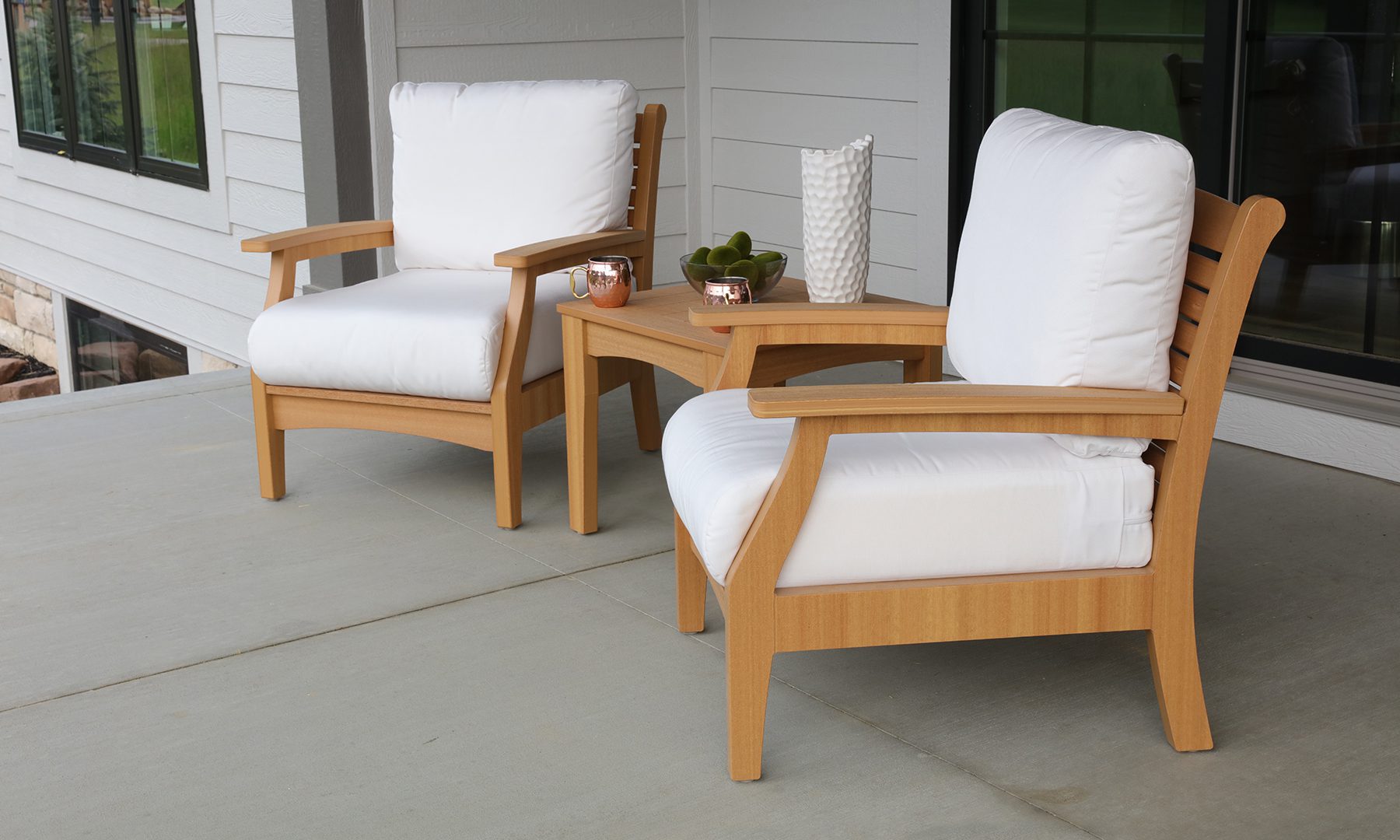 Two poly furniture chairs made to look like wood on a deck.
