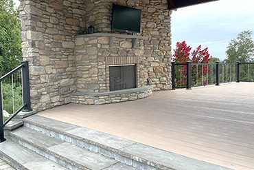 a vinyl deck with an outdoor fireplace
